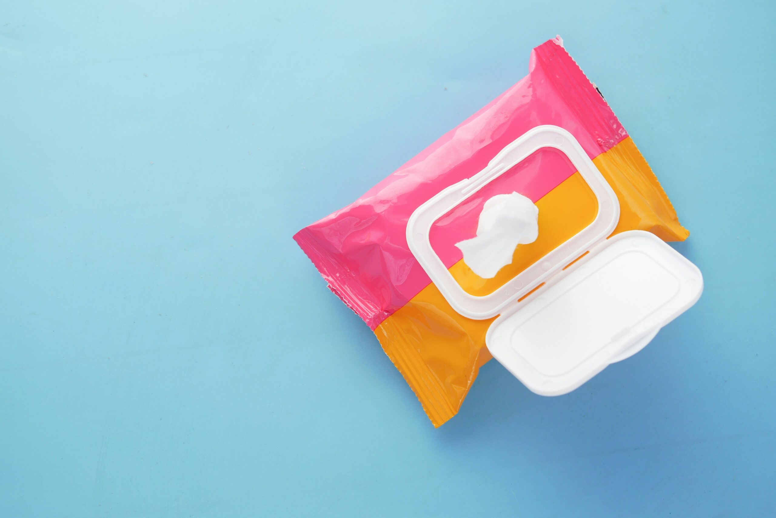 Blue background with and open pink and orange box of makeup wipes
