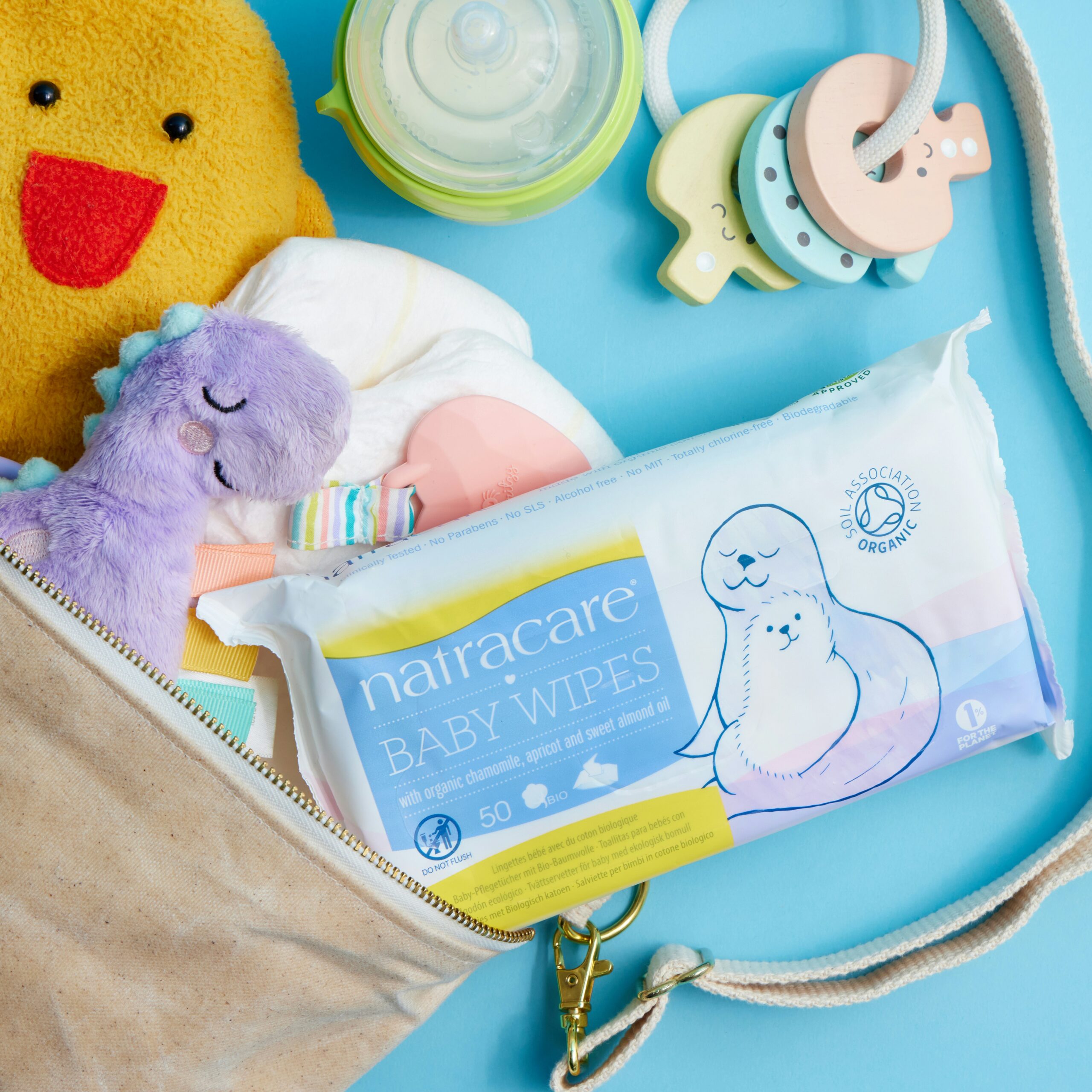 Baby wipes, rubber duck in a purse. Blue background.