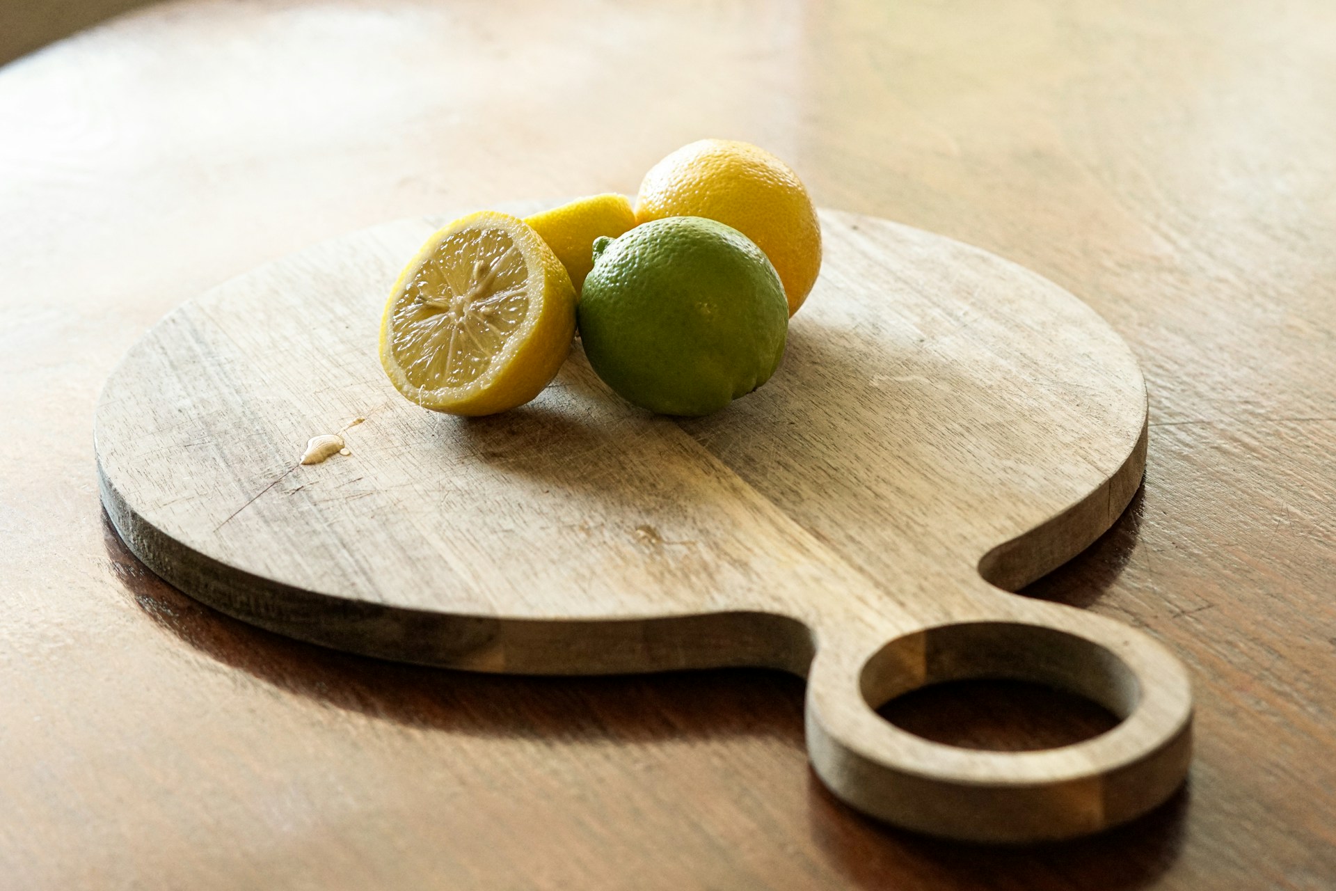Lemons and limes on a cutting board in the kitchen.