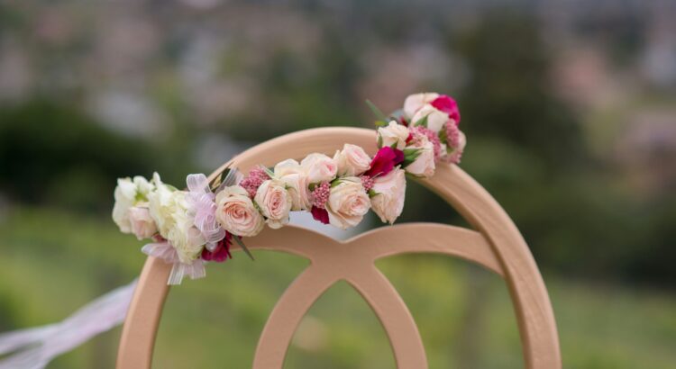Photo of a pink flower crown on the back of a brown chair.