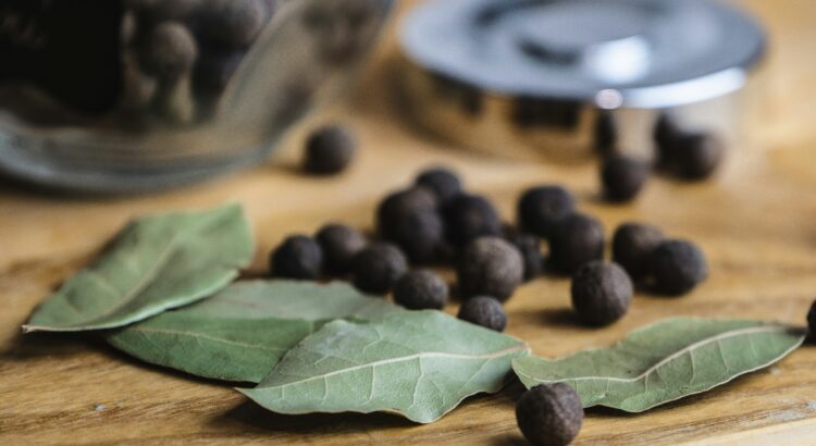 Picture of bay leaves and berries on a wood countertop