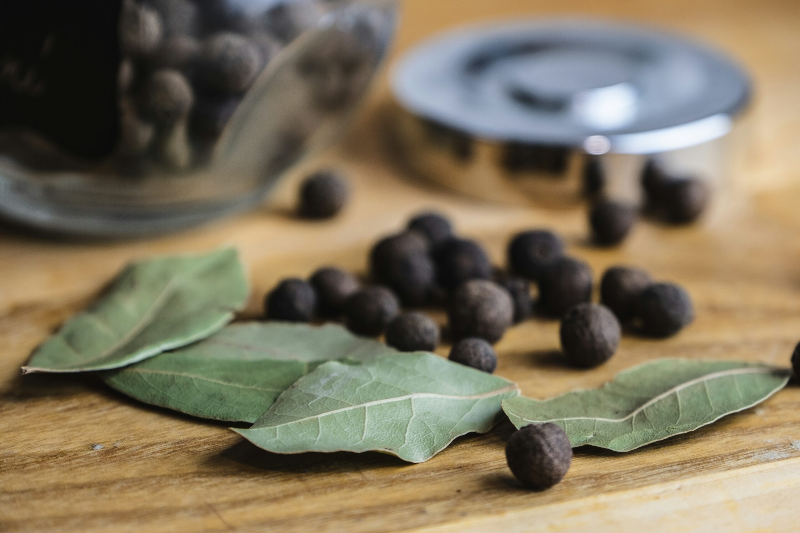 Picture of bay leaves and berries on a wood countertop