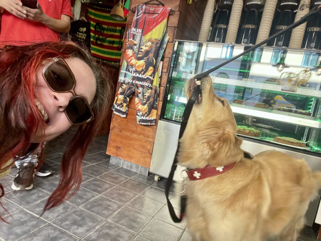 Picture of a woman trying to take a selfie with a golden retriever. Photo is blurry.