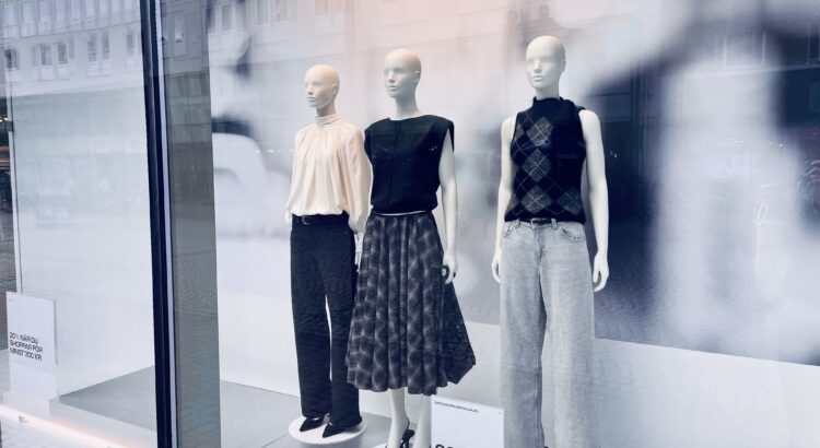 Photo of three white mannequins in a storefront wearing black and white comfortable clothing.